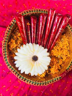 an arrangement of flowers and incense sticks in a bowl