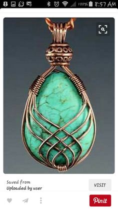 a pendant made out of copper and turquoise stone with an intricate design on the front