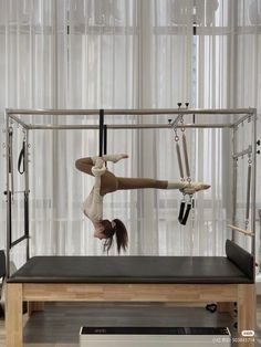 An individual performs an inverted pose on a Pilates Cadillac, showcasing impressive flexibility and core strength in an aerial Pilates challenge. Pilates Poses, Pilates Challenge, Studio Pilates, Gym Room, Pose Yoga, Fitness Inspiration Body, Healthy Lifestyle Inspiration