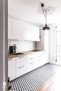 an empty kitchen with white cabinets and black and white checkered floor tiles on the floor