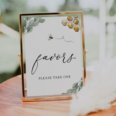 a close up of a table with a sign on it and a white feather in the background