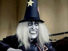 a man dressed as a witch with long blonde hair