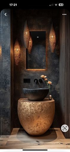 the bathroom is decorated in black and gold with an unusual bowl shaped sink, which sits on top of a wooden countertop