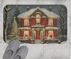 a red house with christmas lights and wreaths on the front door mat