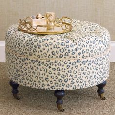 a blue and white ottoman sitting on top of a carpeted floor next to a wall