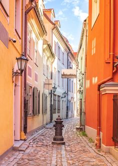 an alleyway with cobblestone and orange buildings on both sides, in europe