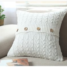 a white pillow sitting on top of a couch