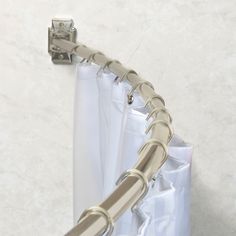 a metal curtain rod is attached to the side of a white curtain in front of a marble wall