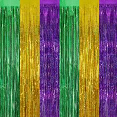 purple, green and gold tinsel fringes are hanging from the side of a wall