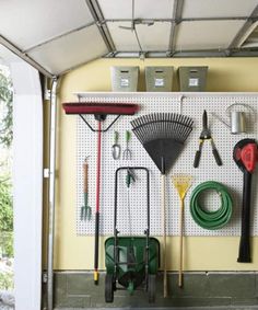 a garage filled with lots of different types of tools and equipment on the wall next to an open door