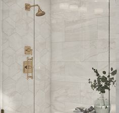 a white tiled bathroom with a shower head and hand held shower faucet in the corner