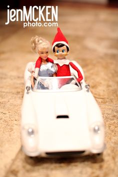 two dolls are sitting in a toy car