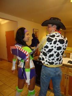 two people dressed up in costumes talking to each other while standing in a kitchen area