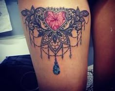 a woman's thigh with a tattoo on it that has a heart in the center