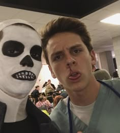 a man standing next to a person in a skeleton mask