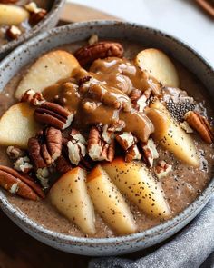 two bowls filled with oatmeal topped with apples and pecans