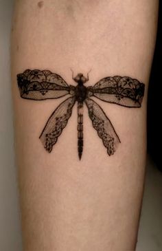 a black and white photo of a dragonfly tattoo