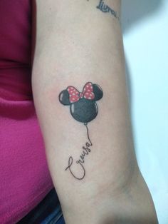 a woman with a tattoo on her arm that has a minnie mouse balloon attached to it