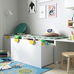 a child's room with toys and books on the floor, including a toy chest