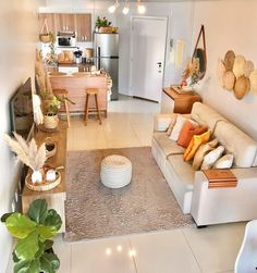 a living room filled with lots of furniture next to a white kitchen and dining area