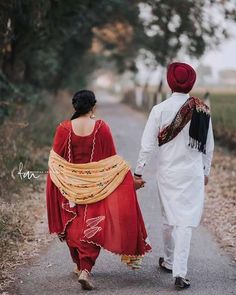 two people walking down a road holding hands