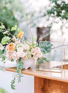 an arrangement of flowers and greenery on a table