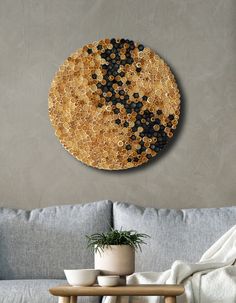 a living room with a couch, table and round artwork on the wall above it