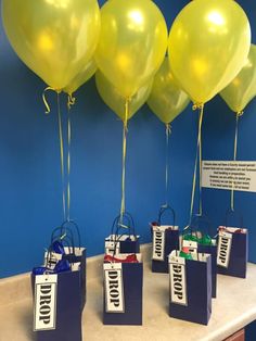 balloons and gift bags are sitting on a table with blue walls in the back ground