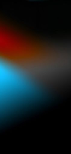 a blurry image of an orange, blue and red object in the dark background