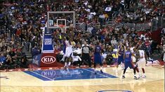 a group of men playing basketball in front of an audience