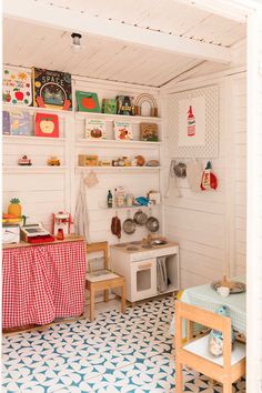 a kitchen with an oven, table and shelves filled with cookware on the wall