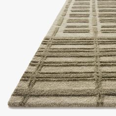 a beige rug with squares and lines on the top, in front of a white background