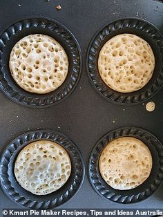 four muffins in a black pan on top of an oven burner with holes