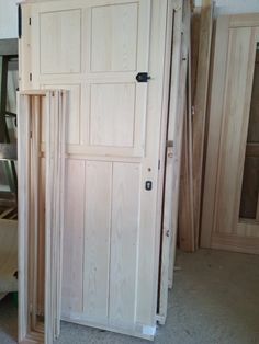 an unfinished wooden door is open in a room