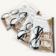 four pairs of reading glasses sitting on top of each other in plastic bags with the words made god written on them