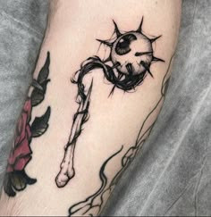 a black and white tattoo on the leg of a person with a rose in it