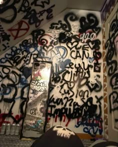 graffiti on the wall and mirror in a room that is covered with other graffiti writing