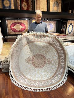 an older man is looking at a large rug