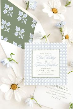 the wedding stationery is laid out on top of each other, with daisies