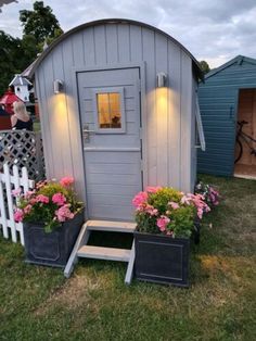 a small shed with flowers in the front