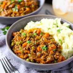 two bowls filled with mashed potatoes, meat and peas on top of a table