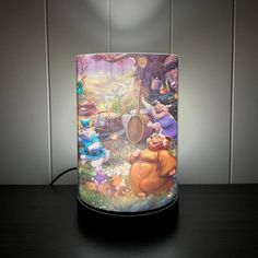 a lamp that is on top of a table with an image of winnie the pooh