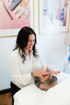 a man getting his hair cut by a woman