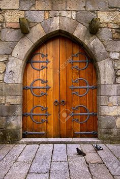 an old wooden door with iron bars on the outside and brick flooring in front