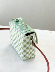 a green and white checkered bag sitting on top of a table