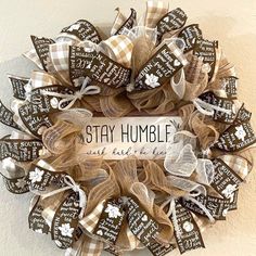 a wreath that says stay humble with brown and white ribbons