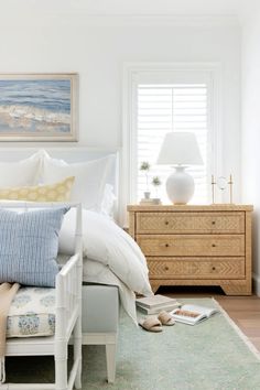 a white bed sitting next to a window in a bedroom