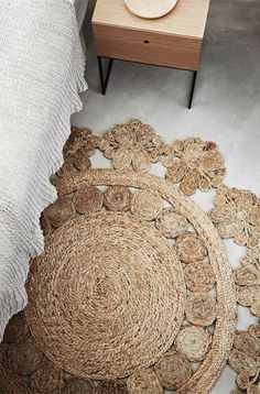 two round rugs are on the floor next to a table with a wooden plate