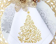 a white and gold christmas tree napkin on top of a doily