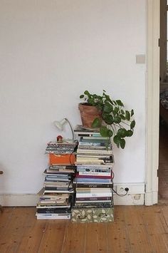 a stack of books sitting on top of a hard wood floor next to a door